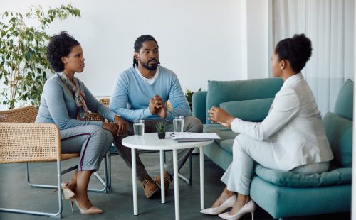 Young back couple and insurance agent communicating during a meeting in the office.