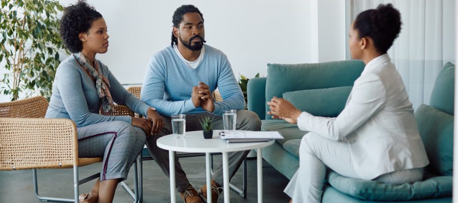 Young back couple and insurance agent communicating during a meeting in the office.